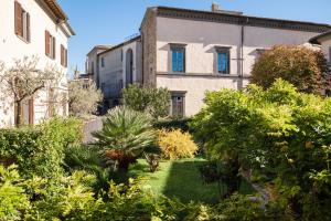 a garden in front of a building with trees at Le Dimore by Borgo Tessile - Feronia in Orvieto