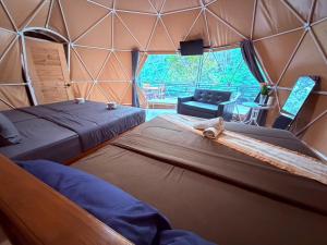 a room with two beds in a tent at Khao Sok River Canoe&Resort in Khao Sok National Park