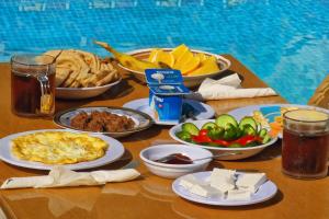 a table with plates of food on a table at Astralis Hotel - Hot Air Balloon View in Al Aqālitah