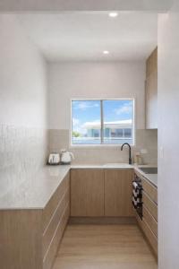 a kitchen with a sink and a window at Beachfront Penthouse With Uninterrupted Ocean Views in Alexandra Headland