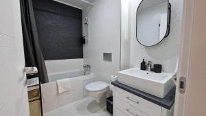 a bathroom with a sink and a toilet and a mirror at Sapphire Suite #pool&parking #Cosmopolis in Ştefăneştii de Sus