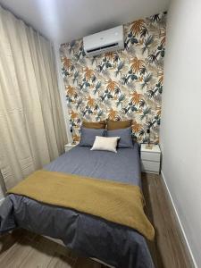 a bedroom with a blue bed with a wallpaper at La Casa de Mara in Madrid