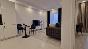 a living room with a couch and a table at Sapphire Suite #pool&parking #Cosmopolis in Ştefăneştii de Sus