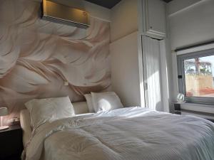 een slaapkamer met een bed met een grote muur bij Casa Del Mare in Kavala