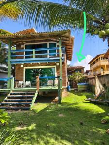 a house with a palm tree in front of it at Edícula 2 quartos frente mar in Ilhéus