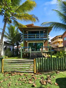 a house with palm trees in front of it at Edícula 2 quartos frente mar in Ilhéus