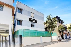 een gebouw met een uithangbord aan de zijkant bij Hotel O Western Avenue Pune Formerly Happy Stay in Méribel Village +27 foto's