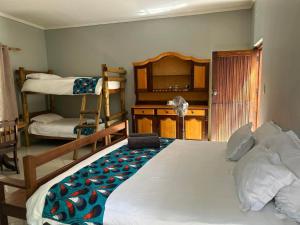 a bedroom with a bed and bunk beds in it at Kameeldoring Guesthouse in Zeerust
