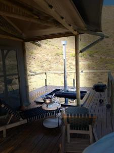 a porch with a grill on a wooden deck at Oudemuur Glamping in Montagu