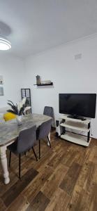 a living room with a table and a flat screen tv at La vagoneta in Cala