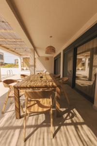 a dining room with a wooden table and chairs at Acacia - Explore your senses in Preveza