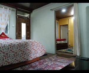 una camera con letto e una stanza con tappeti di Grace Homestay a Darjeeling