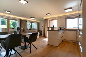 a kitchen and living room with a table and chairs at Waldrand Apartments - by myNests in Ramsau am Dachstein