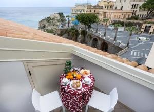 a table on a balcony with a view of the ocean at B&B Island Tropea -Sea View Rooms & Suites- in Tropea