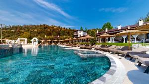 una piscina con sedie e ombrelloni in un resort di Acrotel Athena Pallas & Residence a Elia