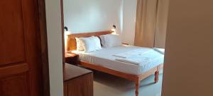 a bedroom with a bed with white sheets and pillows at tippys beach resort in Kovalam