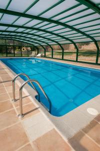 a large swimming pool with an overhead roof at Mas Postius in Montanyola
