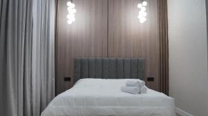 a bedroom with a bed with two towels on it at Zhaily Hotel in Semey