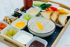 a tray of food with a bowl of rice and vegetables at Zhaily Hotel in Semey +6 photos