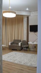 a living room with a couch and a tv at Zhaily Hotel in Semey