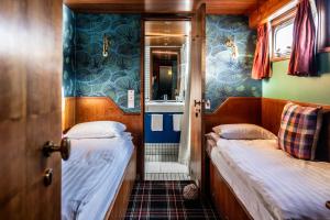 a small room with two beds and a bathroom at Péniche d'hôtes MS Elisabeth in Namur