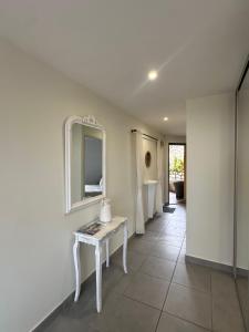 a white room with a table and a mirror at Résidence Le Vénusia - 2 in Port-Vendres