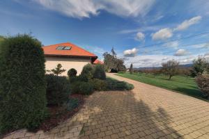 a house with an orange roof and a brick driveway at Pokoj U lesa Zaolší in Vendryně