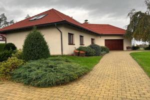 a white house with a red roof and a driveway at Pokoj U lesa Zaolší in Vendryně