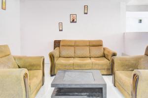 een woonkamer met twee banken en een salontafel bij Hotel O Western Avenue Pune Formerly Happy Stay in Méribel Village