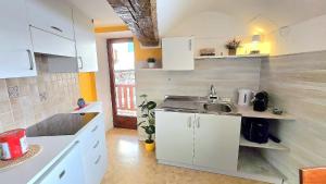 a small kitchen with white cabinets and a sink at Maison Cavalese - Polar Express in Cavalese