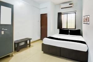 een slaapkamer met een bed, een tafel en een raam bij Hotel O Western Avenue Pune Formerly Happy Stay in Méribel Village