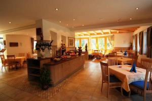 uma grande sala com mesas e cadeiras e um restaurante em Hotel Sterzinger Moos em Vipiteno
