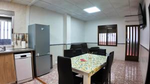 een kamer met een tafel en stoelen en een keuken bij Apartalux Playa Arenal in Burriana