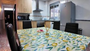 een keuken met een tafel met een tafelkleed met fruit erop bij Apartalux Playa Arenal in Burriana +36 foto's