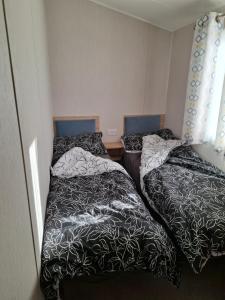 two beds sitting next to each other in a room at Life is Adventure in Great Clacton