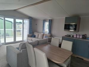 a living room with a table and a couch at Life is Adventure in Great Clacton
