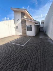 a large white building with a brick driveway at Linda kitnet estilo loft! unidade 2 in Guarapuava