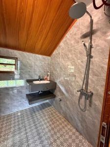 een badkamer met een wastafel en een douche bij Homestay field - bungalow, Ha giang loop tour, motorbikes rental in Ha Giang