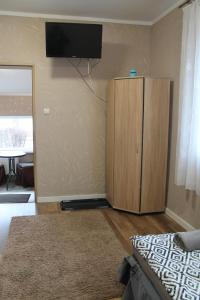 a living room with a television and a wooden cabinet at Noclegi Nad Żerdnem in Czaplinek