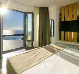 una camera da letto con un letto grande e una grande finestra di Secret Path Luxury Villas a Imerovigli Altre 79 foto