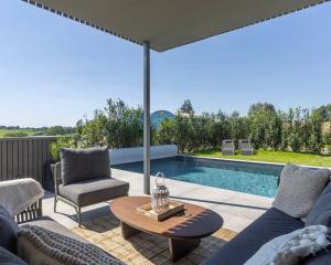 a patio with a table and chairs and a swimming pool at Nomad Village in Verviers