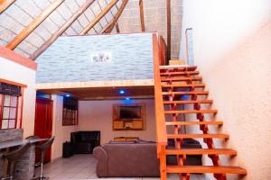 a wooden staircase in a room with a couch at Falcon Lodge Bela in Bela-Bela