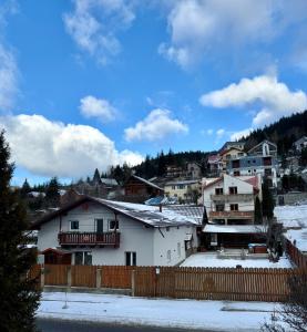 a group of houses in a town in the snow at Casa Aramis in Azuga