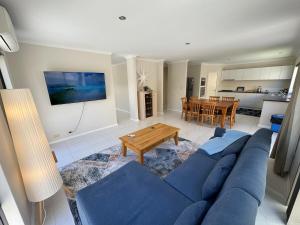 a living room with a blue couch and a table at Ocean Whisper in Wannanup