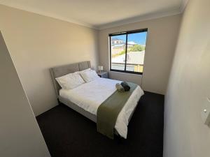 a small bedroom with a bed and a window at Ocean Whisper in Wannanup