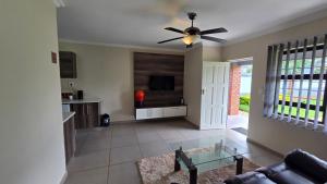 een woonkamer met een plafondventilator en een bank bij Mafini Villa in Centurion