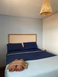 a bed with blue sheets and a towel on it at The Box Container House casa oceano in Imbituba