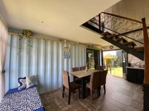 a dining room with a table and chairs and a staircase at The Box Container House casa oceano in Imbituba