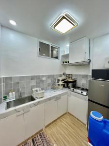 eine Küche mit weißen Schränken und einer Spüle in der Unterkunft Primari Haven in Bantinguil + 6 Fotos