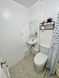 ein weißes Badezimmer mit Toilette und Waschbecken in der Unterkunft Primari Haven in Bantinguil